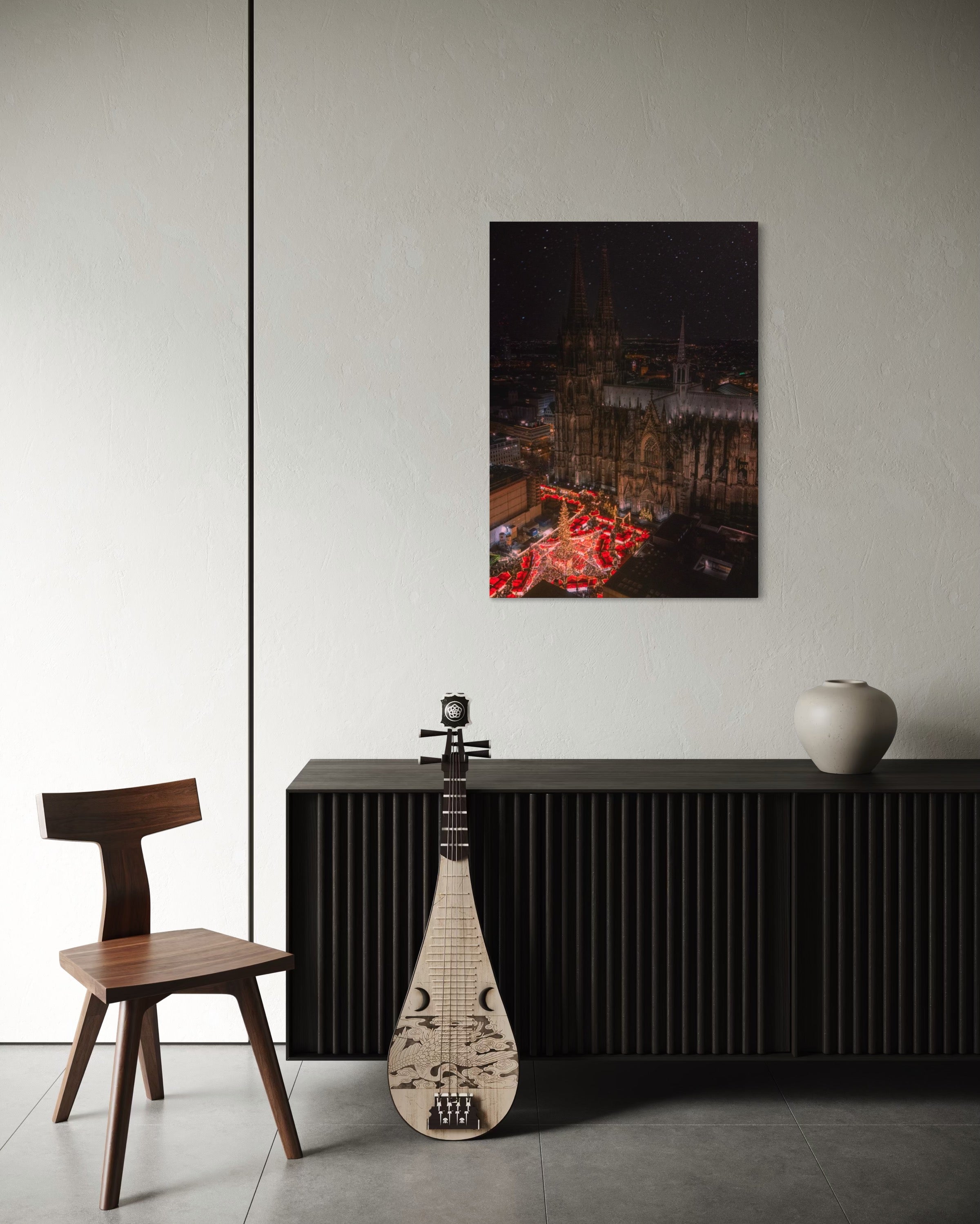 Room interior with a chair, musical instrument, and decorative items against a white wall with a framed picture.